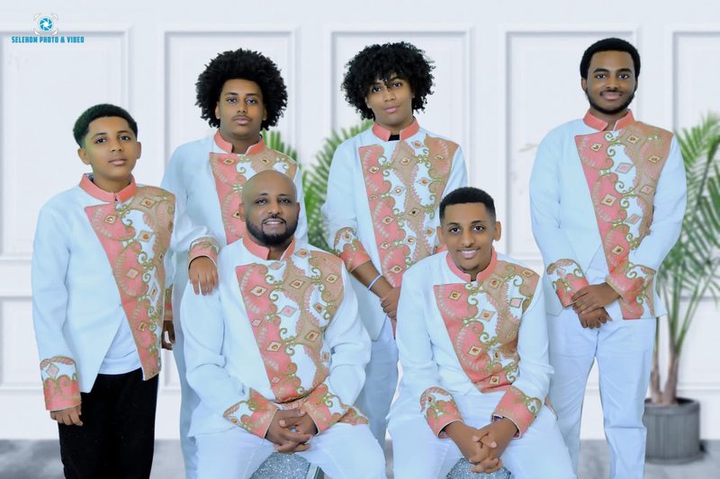 Group portrait in matching white and pink embroidered attire
