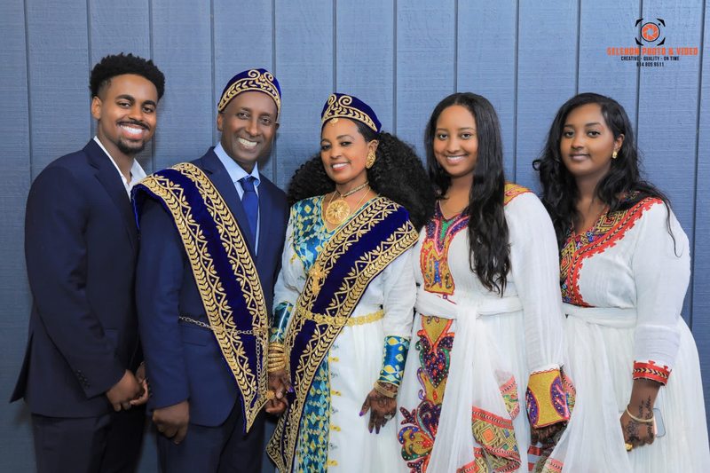 Couple posing with family members in formal and traditional clothing
