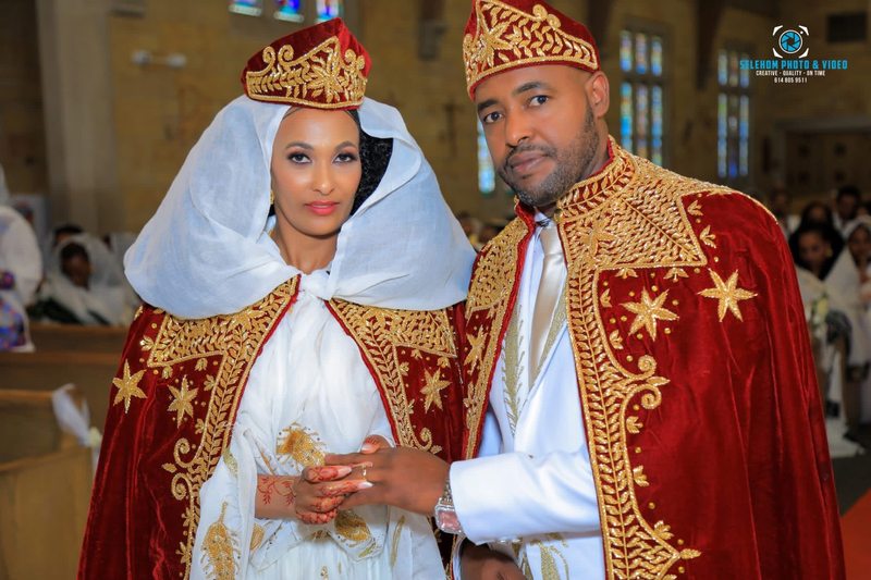 Couple wearing red and gold ceremonial wedding attire