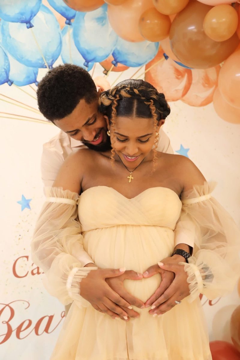 Couple embracing with their hands resting on an expectant mother's belly